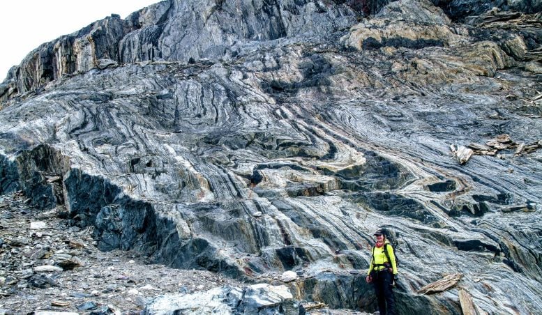 Campo magnetico terrestre: scoperta la sua intensità 3,7 miliardi di anni fa 1 La coautrice dello studio Athena Eyster si trova di fronte a un'ampia esposizione di formazione di ferro a bande, il deposito ricco di ferro da cui venivano estratti antichi segnali di campo magnetico. Credito: Claire Nichols