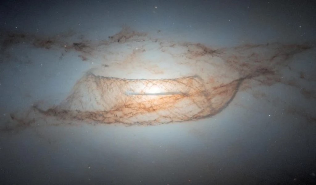 NGC 4753: Hubble svela polvere e materia oscura 1 NGC 4753, catturata dal telescopio Hubble, ha rivelato intricate strutture di polvere e un alone di materia oscura. Questa galassia funge da sito cruciale per studiare la formazione galattica e misurare le distanze cosmiche. Crediti: ESA/Hubble e NASA, L. Kelsey